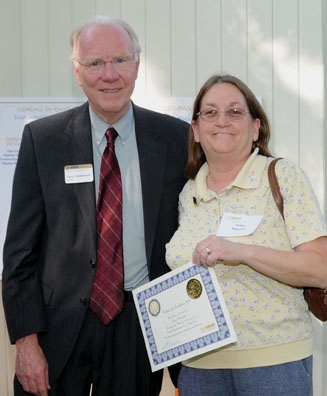 Chancellor Larry Vanderhoef presents a citation for excellence to account manager Susan Ragsdale.