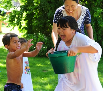Evelyne Morisseau tries to guard her bucket of water. From left are Jayden Robinson, Jasmire Morisseau and Jia Wang, a visiting doctoral student from China.
