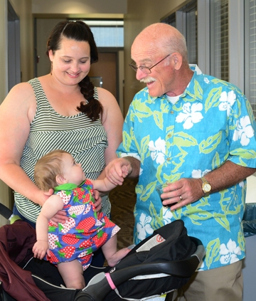 Bill Reisen greets Sarah Wheeler's 7-month-old baby, Etta Palmer, at a retirement party. (Photo by Kathy Keatley Garvey
