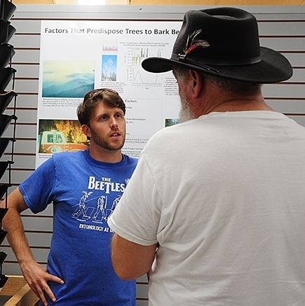 Doctoral student Jackson Audley answers a question at the recent Bohart Museum of Entomology open house on bark beetles. (Photo by Kathy Keatley Garvey)