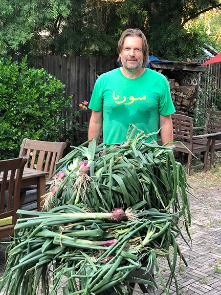 Christian Nansen with a load of onions he harvested from his garden.