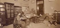 In this 1915 image, Judge William Thomas Hammock of Little Rock, Ark., sits at his desk while his daughter, Maude Hammock, works the 