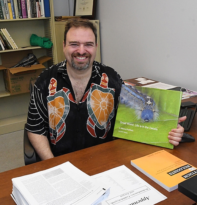 Medical entomologist-geneticist Geoffrey Attardo, shown with his book of macro images, is the winner of the Medical, Urban and Veterinary Entomology Award from the the Pacific Branch, Entomological Society of America.