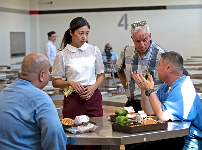 Heile Gantan of Impact Justice (center left) and Ron Strochlic of Nutrition Policy Institute (center right) chat with residents of California State Prison Solano about the quality of their food