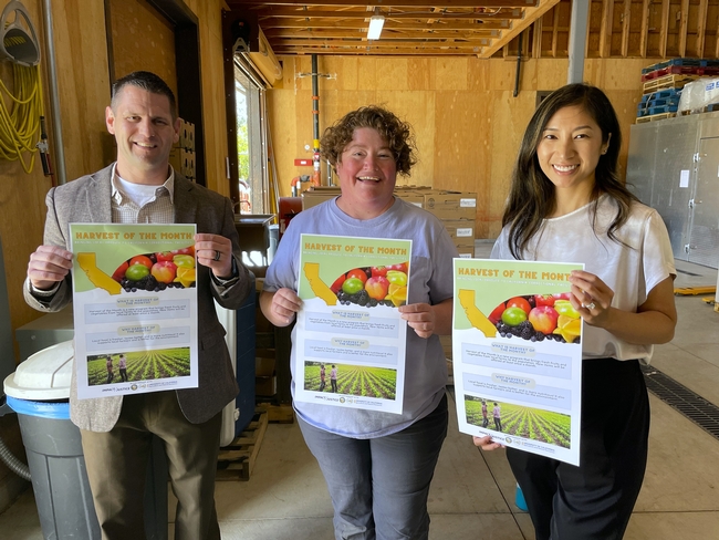 From left, Lance Eshelman, departmental food administrator for CDCR; Hope Sippola, co-owner of Spork; and Heile Gantan, program associate at Impact Justice pose with posters that are displayed in the dining halls of the facilities participating in the program