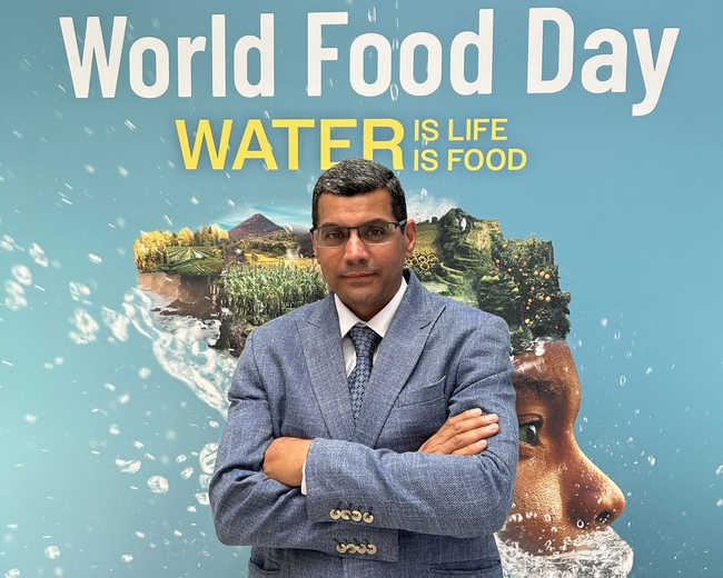 Atef Swelam stands in front of a sign that reads World Food Day