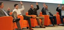 Darren Haver (center) and fellow roundtable participants raise their hands when asked the question, 
