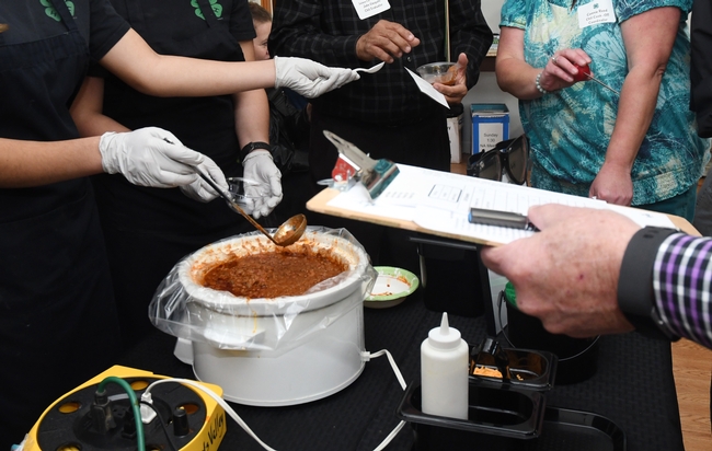 The scenario: crockpot of chili, gloved hands, spoons, and a judge's clipboard. (Photo by Kathy Keatley Garvey)