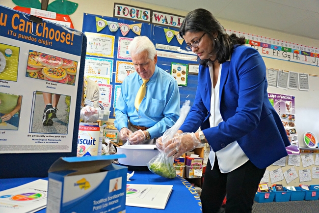 U.S. Congressman Jim Costa and UCCE nutrition, family and consumers sciences advisor for Fresno and Madera counties Mandeep Virk Baker prep salad ingredients.