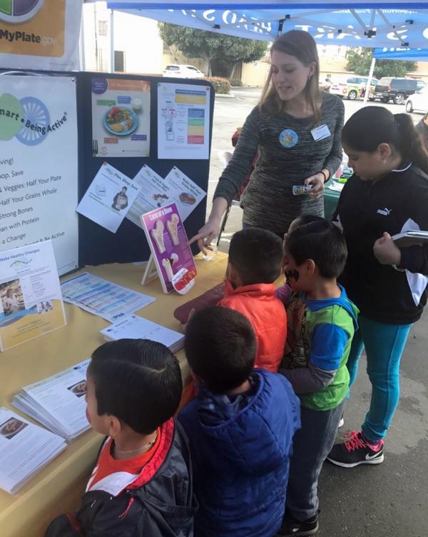 Natalie Price shares nutrition information with families at the Mexican American Opportunities Foundation (MAOF) community fair.