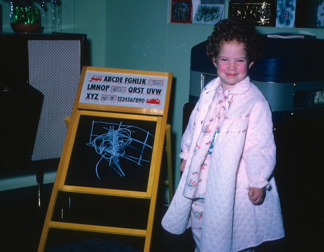 Linda J. Harris as a child, standing by a chalkboard