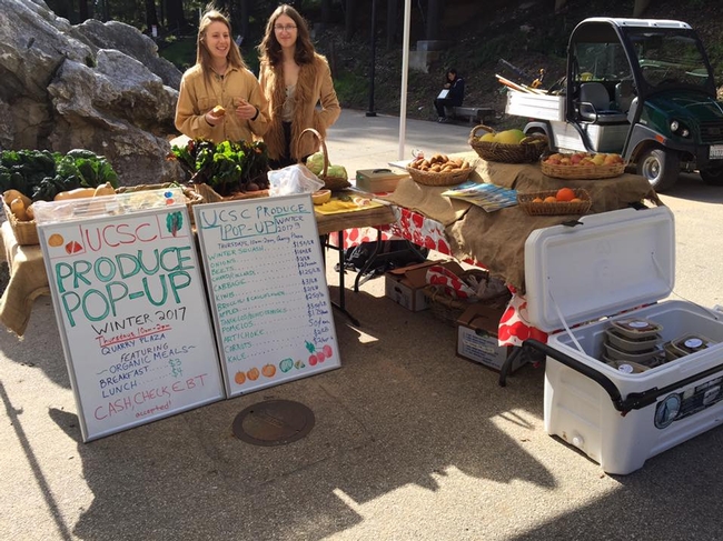 Margaret Bishop (right) and Arianna Khieninson (left) stand behind a table of fresh foods for sale