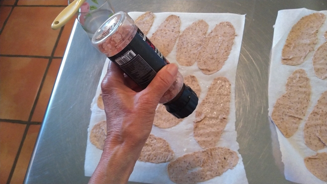 Sprinkling salt on cracker dough