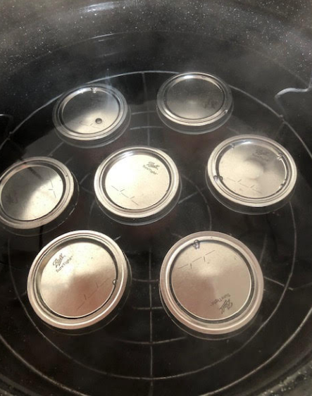 Filled jars added to boiling water canner