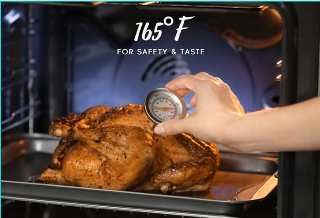 Cooked turkey on an oven rack. A woman's hand is reaching in to check the temperature with a thermometer.