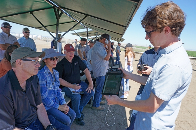 During a drone flight, Emory Silberton shows real-time crop monitoring on a tablet computer.