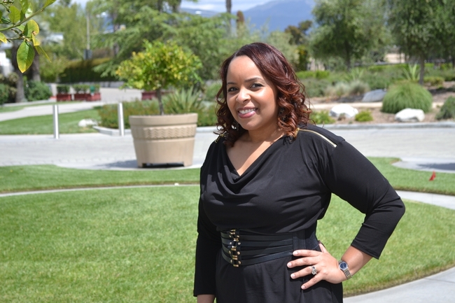 Elizabeth McSwain headshot image, McSwain is standing in front of a lush green garden in San Bernardino County.