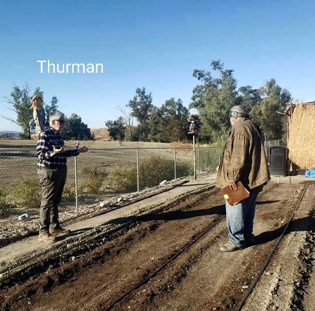 Two people stand facing each other in a garden bed: one, UC Master Gardener Program volunteer Thurman Howard, the other person, a member of the Soboba Band of Luiseño Indians Tribe. B