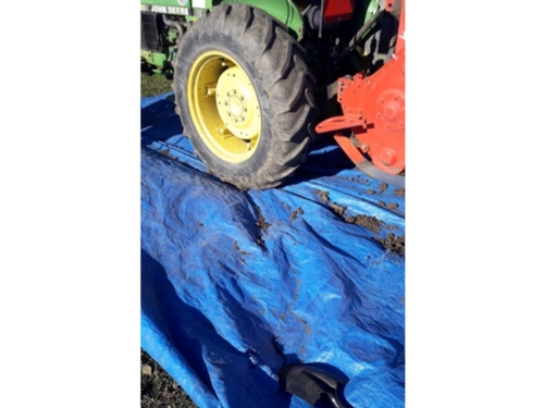 Soil brushed from tiller and tractor tires onto a plastic tarp.