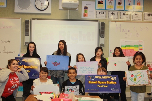 Rowell Spirit Club members and their teacher Ms Alarcon display student artwork and the new Rowell Space Station Sign