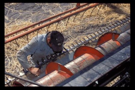 worker inspecting combine rake