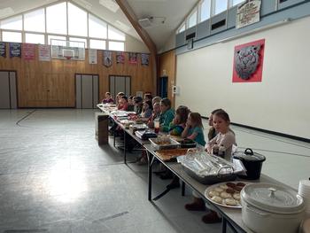 Kids sitting at long tables with food on the tables