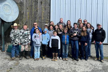 4-H youth and parents posed for a picture at the Foggy Bottoms Boys farm.