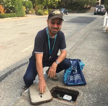MMG volunteer Roger Pancoska demonstrates how to be a leak detector by reading your water meter. Photo: Nancy Gibbs