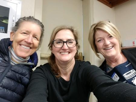 Three volunteers smiling at a workshop