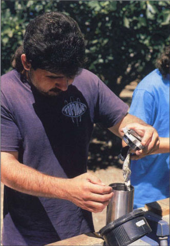 Mario Salinas prepares to measure stem water potential with a pressure chamber.