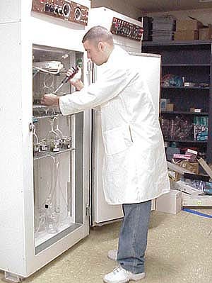 Kyle Emery tests tadpoles in an environmental chamber, which maintains constant temperature and humidity as well as a light-dark regime.