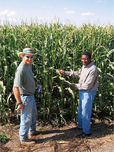 Ladi Asgill (right) of Sustainable Conservation and Andy Zylstra of Zylstra Dairy, which hosted conservation tillage field trials, examine Zylstra's corn crop.