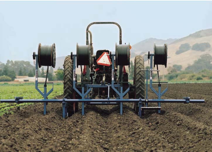 Specialized equipment (shown here, by Andros Engineering) is used to install drip tape 8 to 12 inches below the soil surface, at a cost of about $600 to $1,000 per acre. Despite this price, studies show that improved irrigation efficiency and yield benefits increase profits for growers in the San Joaquin Valley, compared with sprinkle or furrow irrigation.