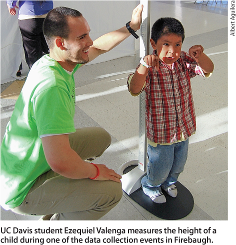 UC Davis student Ezequiel Valenga measures the height of a child during one of the data collection events in Firebaugh.