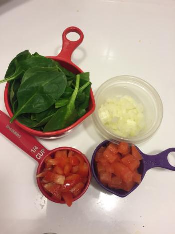 Prepare 1 handful of spinach, 1/4 cup bell peppers, 1/4 cup tomatoes, and 1/4 of a small onion.