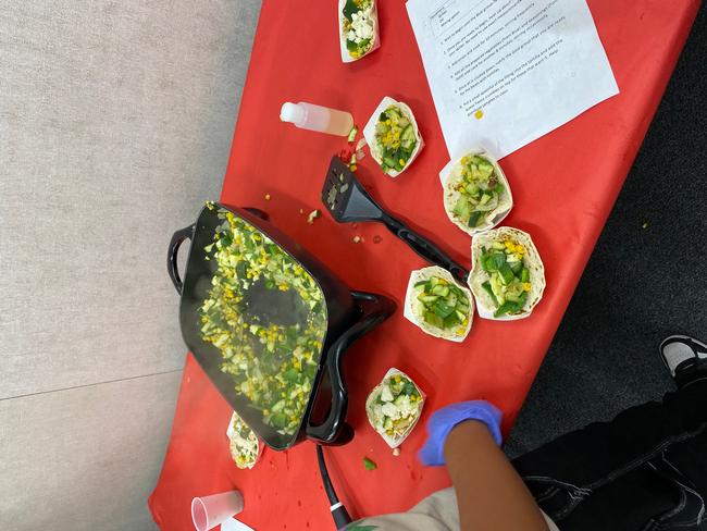 Student plating vegetable sauté after cooking activity