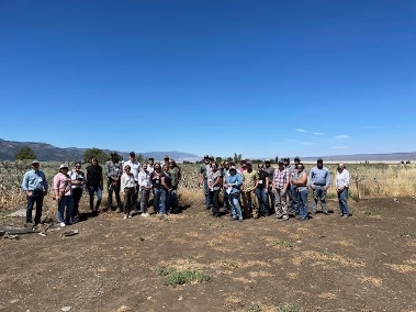 A group photo in open space under a blue sky.