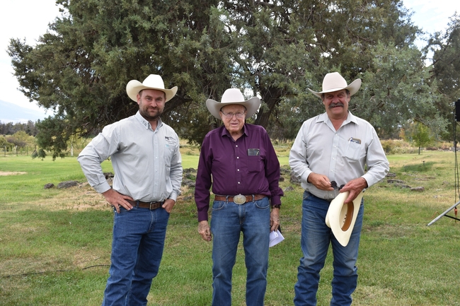 Three men wearing cowboy hats stand in front of big tree. Pete holds another cowboy hat and sunglasses.