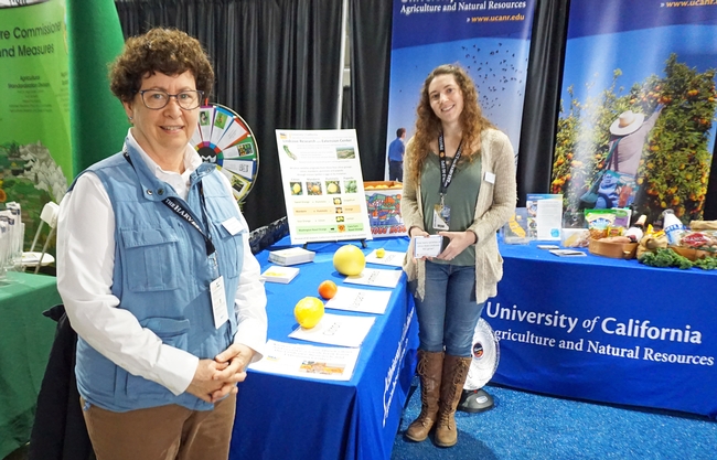 Lindcove director Beth Grafton-Cardwell, left, and staff research associate Stephanie Doria hand out citrus at the UC ANR booth at World Ag Expo.