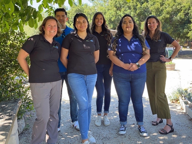 Miguel Diaz, Kelly Hong, Melissa LaFreniere, Abbi Marrs, Mishelle Petit, Rosa Vargas stand under a tree. Betsy Plascencia and Melissa Rorabough are missing from the picture.