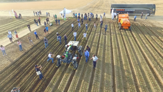 Aerial view of people and equipment at demo day in the field at Fresno State Farm.