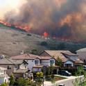 Fires burn across the hillside near homes in Southern California.