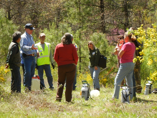 Glenn Nader, wearing blue cap, in the field with ranchers.