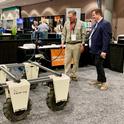 Steve Fennimore, UC Cooperative Extension weed management specialist, and Gabe Youtsey, chief innovation officer, test drive a farm-ng robot in the expo area of FIRA USA.