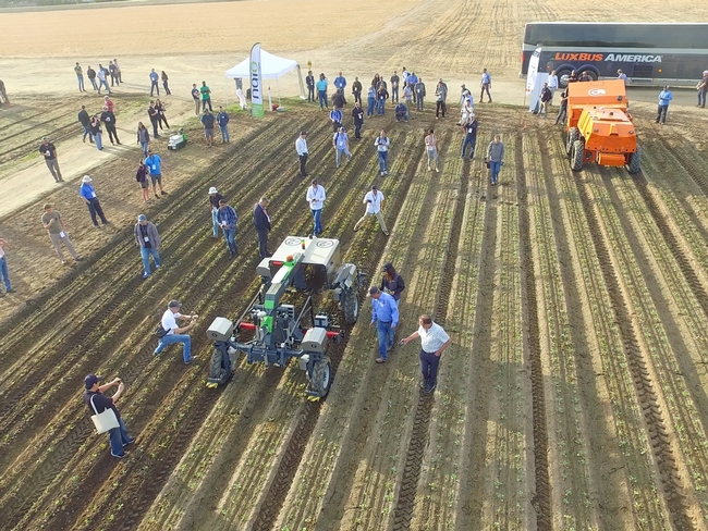 Aerial view of people and autonomous farm machinery on demo day at the Fresno State Farm.
