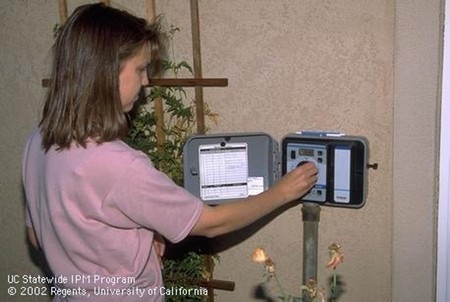 Photo of woman adjusting her irrigation controller
