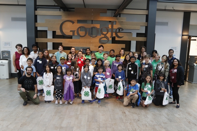 CS Pathway Team, volunteers, Googlers, and youth participants posing in front of a Google sign.