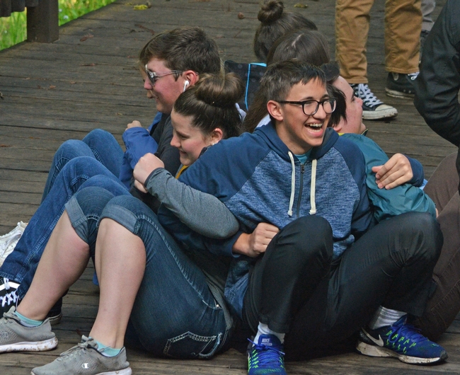 Group of youth linking arms and back to back in an activity