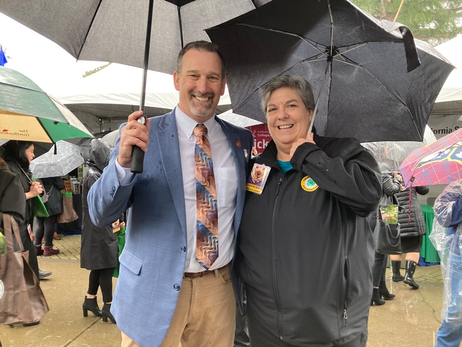 Glenda Humiston and Brian Dahle stand together under an umbrella.