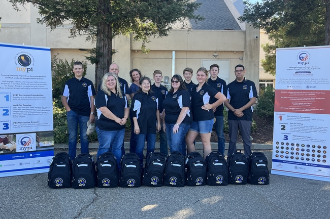Group of people who completed the MyPI instructor certification workshop, with their emergency backpack kits